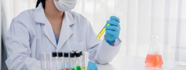 Laboratuvar araştırmacısı laboratuvar tüpünde renkli kimyasal sıvı kullanarak yeni ilaç ya da tedavi geliştirir. Laboratuvar ekipmanları ile bilimsel uzmanlık ile sağlık hizmetlerinin teknolojik gelişimi. Panorama Katı