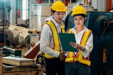 Profesyonel kalite kontrol müfettişi fabrikadaki makine ve imalat sürecinde güvenlik denetimi yapıyor. Ağır sanayi tesislerinde işlem optimizasyonunu denetleyen mühendisler. Örnek gösteriliyor