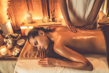 Beyaz kadın müşteri stres önleyici spa masajının keyfini çıkarıyor ve lüks otel ya da otelde sıcak mum ışığında güzellik teniyle eğleniyor. Sessiz.