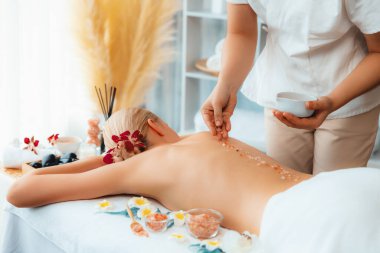 Lüks spa salonlarında sıcak mum ışığında cilt bakımı yaptıran kadın müşteri. Sağlık Spa vücut fırçasında tuz temizleme güzellik tedavisi. Sessiz.