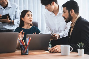 Profesyonel Asyalı çalışanlar, şirket ofisinde takım olarak çalışarak iş planları ve bilgisayarla başarılı olmak için verileri tartışırlar. Modern ofis çalışanı takım çalışması konsepti. Uyum