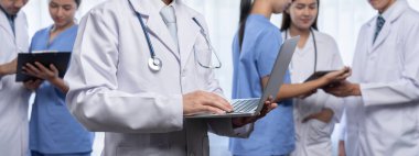 Hastanede dizüstü bilgisayar ve tabletle birlikte çalışan doktor hemşire ve sağlık uzmanlarına sahip tıbbi personel ekibi. Panoramik pankartta tıbbi işyeri ve sağlık hizmetleri topluluğu. Neoterik