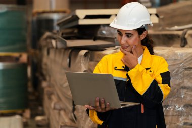 Kadın mühendis veya fabrika müfettişi, metal çelik maddeler için envanter kontrolü ve kalite kontrolü yaparak, ağır endüstriyel üretim optimizasyonuna ve imalat güvenliğine katkıda bulunur. Örnek gösteriliyor