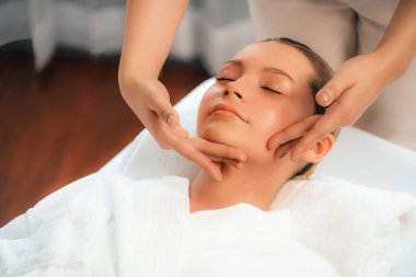 Kafkasyalı kadın stres önleyici kafa masajından ve lüks tatil beldesi ya da otel spa salonundaki modern ışık ortamında yüz güzelliği eğlencelerini şımartmaktan hoşlanıyor. Sessiz.