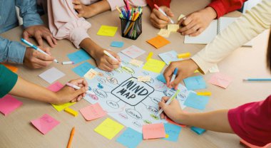 Profesyonel başlangıç grubu zihin haritası kullanarak yaratıcı pazarlama fikrini paylaşıyor. Genç yetenekli iş adamları yapışkan notlar yazarken beyin fırtınası planı yapıyorlar. Eline odaklan. - Yakın çekim. Değiştirilmiş.