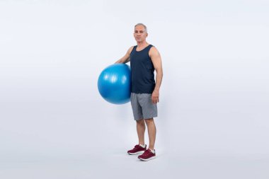 Vücut uzunluğu tam, atletik ve sportif son sınıf öğrencisi izole arka planda ayakta duran topa egzersiz yaptırıyor. Emeklilikten sonra sağlıklı ve aktif bir yaşam tarzı. Etki