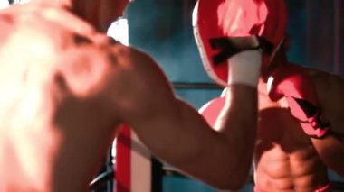 Asyalı ve Kafkasyalı Muay Thai boksörü boks antrenmanında boks antrenmanında boks antrenörüne yumruk atma, Muay Thai boks tekniği ve becerilerini sergileme. Impetus