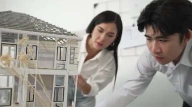 Profesyonel kooperatif beyaz mimar mühendis ekibi ev modelini dikkatle incelerken beyaz modern ofisteki model yapısı hakkında tartışırlar. Yaratıcı karar ve takım çalışması. - Yakın çekim. Tertemiz..