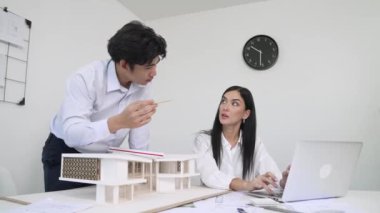 Happy, mimari belge ve ev modeli ile toplantı masasında dizüstü bilgisayar analiz verilerini kullanarak birlikte çalışan profesyonel mimar takımı ile işbirliği yapıyor. Yaratıcı tasarım konsepti. Tertemiz..