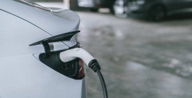 Alış veriş merkezinin otoparkında EV elektrikli araba şarjı şehir merkezindeki sürdürülebilirlik yaşam tarzını yeşil, temiz, yeniden şarj edilebilir elektrikli araç iç organları ile gösteriyor.