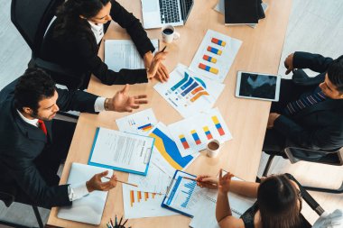 İş adamları grup toplantısı ofiste yukarıdan çekildi. İş kadınları, iş adamları ve ofis çalışanları toplantı masasında proje planlama belgeleriyle takım konferansında çalışıyorlar. Jivy