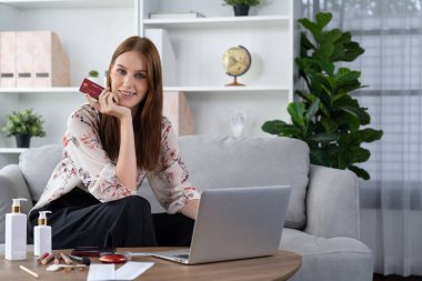 Genç mutlu kadın internetten alışveriş yaparak ürün satın alırken aynı zamanda internet üzerinden online ödeme sistemi ile çevrimiçi mağaza platformundan en yüksek siber güvenlik tarafından korunan ürünler sipariş ediyor.