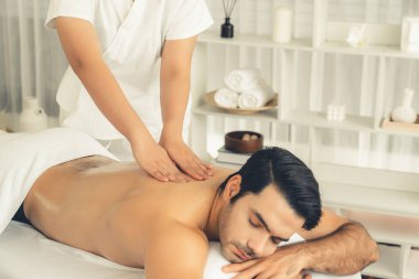 Kafkas erkek müşteri stres önleyici spa masajının keyfini çıkarıyor ve lüks otel veya oteldeki gündüz açık hava ortamında güzellik derisi eğlencesi ile şımartıyor. Sessiz.