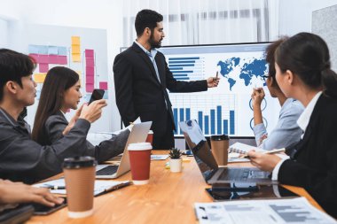 Pazarlama stratejisi için modern toplantıda veri analizi paneli ekranında sunan bir işadamı. Bir grup iş adamıyla konferans odasında iş sunumu. Uyum