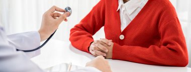 Hasta klinikte ya da hastane ofisinde doktor randevusuna gidiyor. Hastaların nabzını steteskopla kontrol ederken, doktor semptomları muayene ediyor ve teşhis ediyor. Panorama Katı