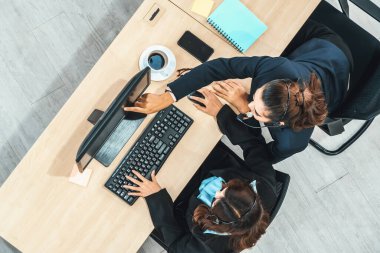 Ofiste bilgisayar başında çalışan, kulaklık takan iş adamları. Jivy