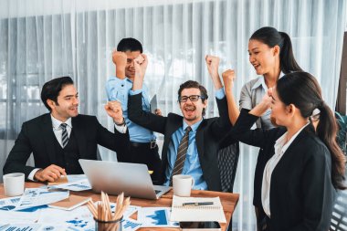 Kutlama jesti ve başarılı takım çalışması yapan bir grup mutlu iş adamı. Çeşitli yarış bürosu çalışanları şirket ofisinde pazarlama planlamasında ilerleme kaydettikten sonra kutlama yapıyorlar. Çok titiz.