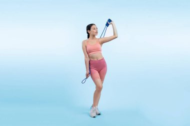 Spor giyim sektöründe genç enerjik Asyalı kadın atlıyor ya da atlıyor stüdyo çekimlerinde izole edilmiş arka planda portre pozu veriyor. Kardiyo egzersiz aleti ve sağlıklı vücut bakımı yaşam tarzı. Kuvvetli