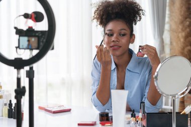 Kadın nüfuzlu kişi canlı yayında video görüntülerini çekiyor. Makyaj çok önemli sosyal medya ya da blog. Kozmetik stüdyosu ışıklandırmalı mutlu genç kız çevrimiçi pazarlama oturumu yayını için..