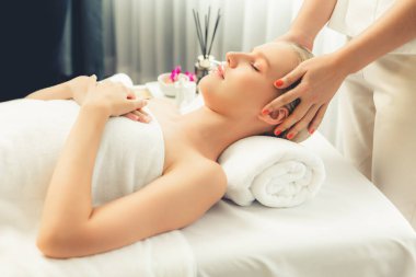 Kafkasyalı kadın stres önleyici kafa masajından ve lüks tatil beldesi ya da otel spa salonundaki modern ışık ortamında yüz güzelliği eğlencelerini şımartmaktan hoşlanıyor. Sessiz.