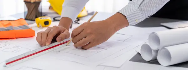 Architect or engineer working on building blueprint, contractor designing and drawing blueprint layout for building construction project. Civil engineer and architectural design concept. Insight