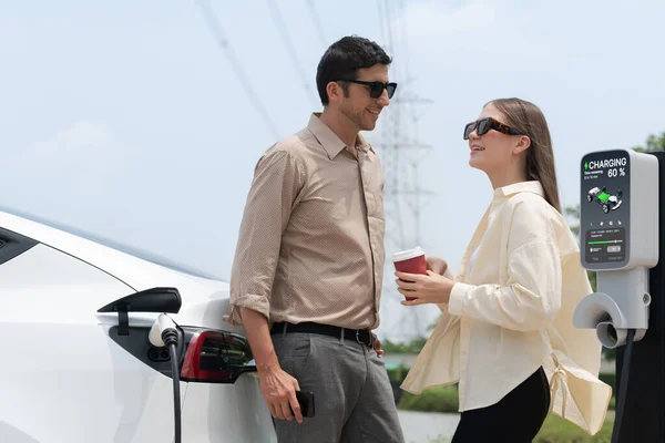 Junges Paar Mit Kaffee Lädt Elektroauto Batterie Ladestation Auf Die — Stockfoto