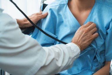 Profesyonel üniformalı doktor hastanedeki ya da klinikteki hastayı muayene ediyor. Sağlık, tıbbi ve doktor servis konsepti. Jivy