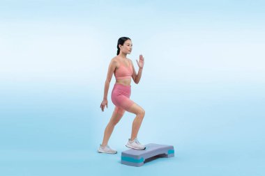 Çalışkan, enerjik bir kadın atölyede egzersiz yapıyor. Kardiyo aerobik hareketleriyle izole bir arka plan. Genç atletik Asyalı kadın mahareti ve dayanıklılık eğitimi konsepti.