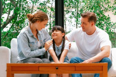 Ebeveynler kızlarını sevgi dolu kucaklaşmalarla rahatlatıyorlar, onun güvende ve korkudan korunmasına yardım ediyorlar, başını omzuna yaslıyorlar. Mutlu aile sevgisi ve çocuk bakımı konsepti. Eşzamanlama