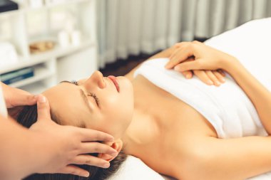 Kafkasyalı kadın stres önleyici kafa masajından ve lüks tatil beldesi ya da otel spa salonundaki modern ışık ortamında yüz güzelliği eğlencelerini şımartmaktan hoşlanıyor. Sessiz.
