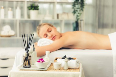Aromaterapi masajı gündüz atmosferinde ya da spa salonunda bulanık bir kadına odak dekor ve spa aksesuarları kurarak tatil köyünde ya da otel arka planında keyifli aroma spa masajı yapan bir masaj. Sessiz.