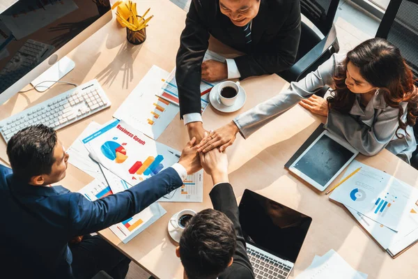 Happy business people celebrate teamwork success together with joy at office table shot from top view . Young businessman and businesswoman workers express cheerful victory show unity support . Jivy