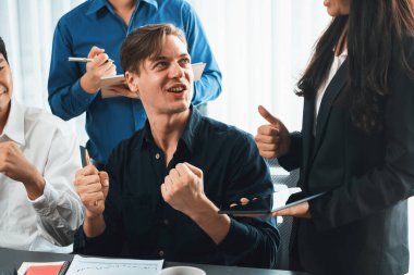 Heyecanlı ve mutlu bir ofis çalışanı başarılı bir stratejik iş pazarlama planlaması yaptıktan sonra kutlama yapıyor. Takım çalışması ve olumlu tutum verimli ve destekleyici bir iş yeri yaratır. Tedbirli