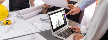 Mühendis ve mimar birlikte çalışarak ayrıntılı bir dijital iç mimari ya da yapı tasarımı için dizüstü bilgisayar kullanarak beyin fırtınası yapıyor ve tasarım yapıyor. İçgörü