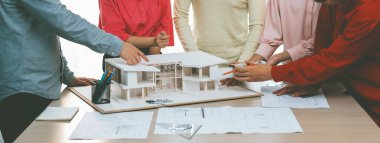 Profesyonel iç mimari ekibinin ev malzemelerini tartışırken akıllı mühendis ekibinin ev inşaatı hakkında beyin fırtınası yaptığı bir görüntü. Yaratıcı çalışma ve takım çalışması konsepti. Değiştirilmiş