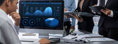 İş zekası ve veri analizi kavramı. Analizci ekibi laptop ekranında finansal veri analizi üzerinde çalışıyor. Etkili iş stratejik planlama için pazarlama göstergesi olarak. İçgörü