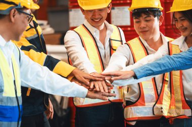 Güçlü ve birleşik bir fabrika işçisi grubu ağır çelik endüstrisi fabrikasında el ele vererek çeşitli endüstriyel mühendislik alanlarında takım çalışması ve takım oluşturma kavramını örnek gösterdiler..