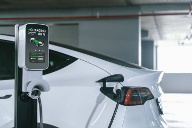 Alış veriş merkezinin otoparkında EV elektrikli araba şarjı şehir merkezindeki sürdürülebilirlik yaşam tarzını yeşil, temiz, yeniden şarj edilebilir elektrikli araç iç organları ile gösteriyor.