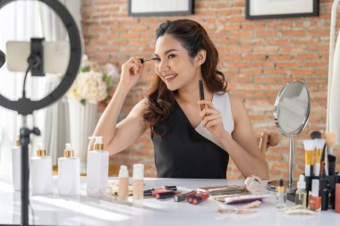 Asyalı Kadın Etkilenen Vlog 'ta canlı yayın yapan videolar sosyal medya ya da blog' un çoğunu oluşturuyor. Kozmetik stüdyosu ışıklandırmalı mutlu genç kız çevrimiçi pazarlama oturumu yayını için.