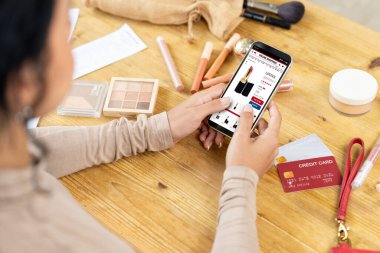 İnternet pazarından alışveriş yapan kadın modern yaşam tarzı için satış malzemeleri arıyor ve önemli siber güvenlik yazılımları tarafından korunan cüzdandan çevrimiçi ödeme için kredi kartı kullanıyor