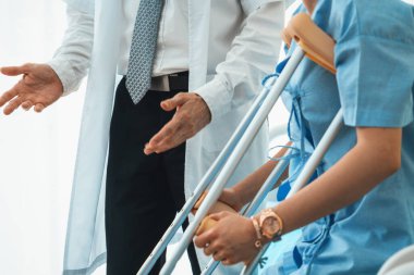 Doktor hastanede koltuk değnekli hastayla ilgileniyor. Fizyoterapist ve bacak yaralanması konsepti. Jivy