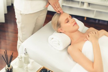 Kafkasyalı kadın stres önleyici kafa masajından ve lüks tatil beldesi ya da otel spa salonundaki modern ışık ortamında yüz güzelliği eğlencelerini şımartmaktan hoşlanıyor. Sessiz.