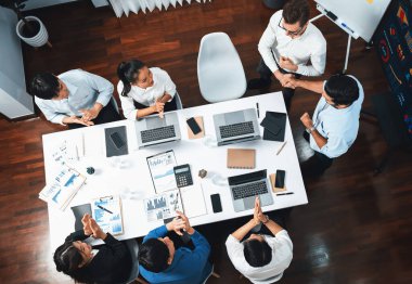 Üst düzey ofis çalışanları stratejik iş pazarlama toplantısı üzerine anlaşma yaptıktan sonra el sıkışıyor. Takım çalışması ve olumlu tutum verimli ve destekleyici bir iş yeri yaratır. Tedbirli