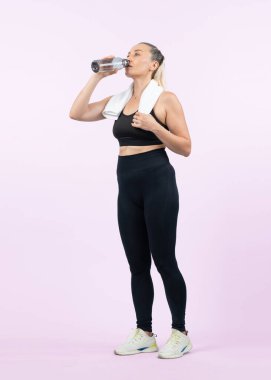 Vücut uzunluğunun tamamı atletik ve sportif yaşlı kadın içme suyu ve izole edilmiş arka planda egzersiz yaptıktan sonra ara veriyor. Emeklilikten sonra sağlıklı, aktif bir fiziğe ve vücut bakımına sahip. Etki