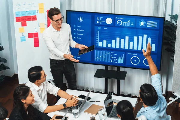 Presentation in office or meeting room with analyst team utilizing BI Fintech to analyze financial data. Businesspeople analyzing BI dashboard power display on TV screen for strategic planning.Prudent