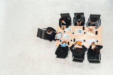 İş adamları grup toplantısı ofiste yukarıdan çekildi. İş kadınları, iş adamları ve ofis çalışanları toplantı masasında proje planlama belgeleriyle takım konferansında çalışıyorlar. Jivy