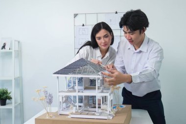 Kooperatif mühendis ekibinin portresi ev modelini ölçmek için cetvel ve mimari ekipmanlar kullanarak birlikte çalışıyor. Yaratıcı iş tasarımı ve takım çalışması konsepti. Tertemiz...