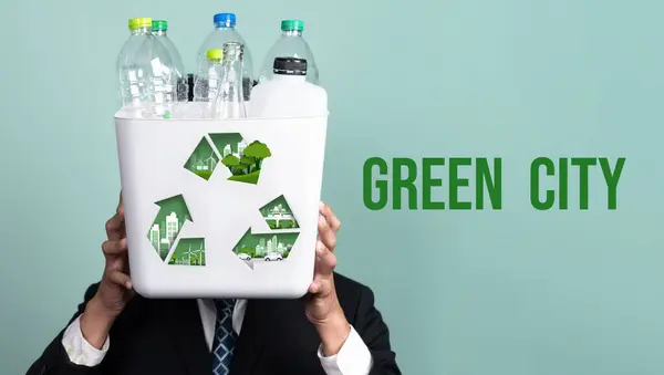 Eco friendly business with ESG commitment to make greener campaign with corporate recycling and waste management. Businessman hold recycle bin promoting sustainable clean environment. Reliance