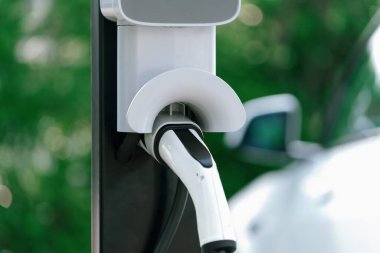 Platform enerji sosunu şarj etmek için şarj prizi takılı EV şarj istasyonu kapatıldı. Daha iyi bir gelecek için çevre dostu EV araba için alternatif temiz ve sürdürülebilir enerji. Eşzamanlama