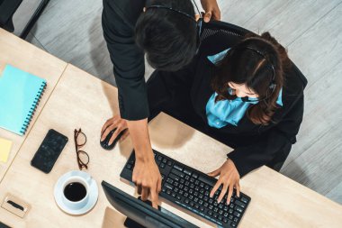 Ofiste bilgisayar başında çalışan, kulaklık takan iş adamları. Jivy